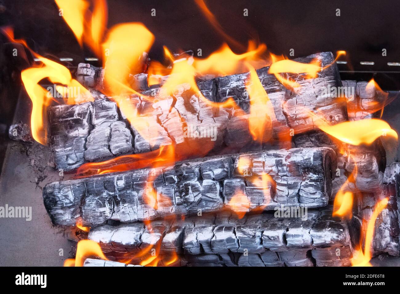 Makro Textur Flamme von brennenden Holzstämmen im Kamin. Holzfeuer für den Grill vorbereitet. Stockfoto