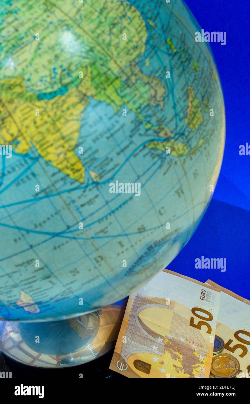 Globus mit Geldscheinen auf blauem Hintergrund Stockfoto