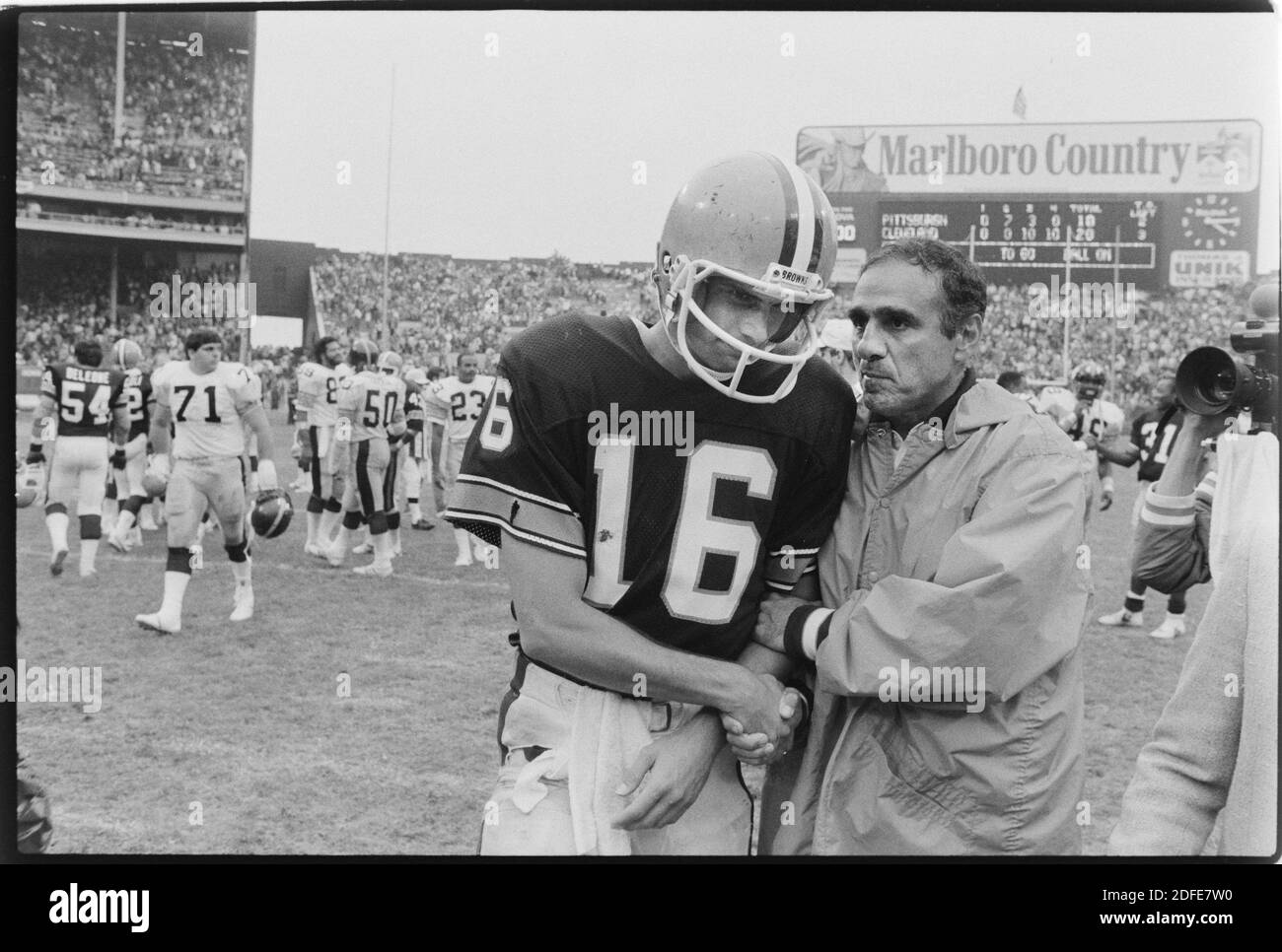 Cleveland Browns Trainer Sam Rutigliano umarmt Cleveland Quarterback Paul McDonald nach einem 20-10 Sieg gegen den Rivalen Pittsburgh Steelers in Cleveland am 23. September 1984. Das Spiel markiert Rutigliano den letzten Sieg als Browns Trainer. Er wurde später in der Saison nach einem Rekord von 1-7 entlassen. Ernie Mastroianni Stockfoto