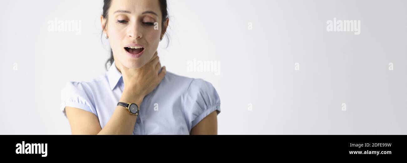 Frustrierte Frau hält ihre Kehle mit der Hand und hustet Stockfoto