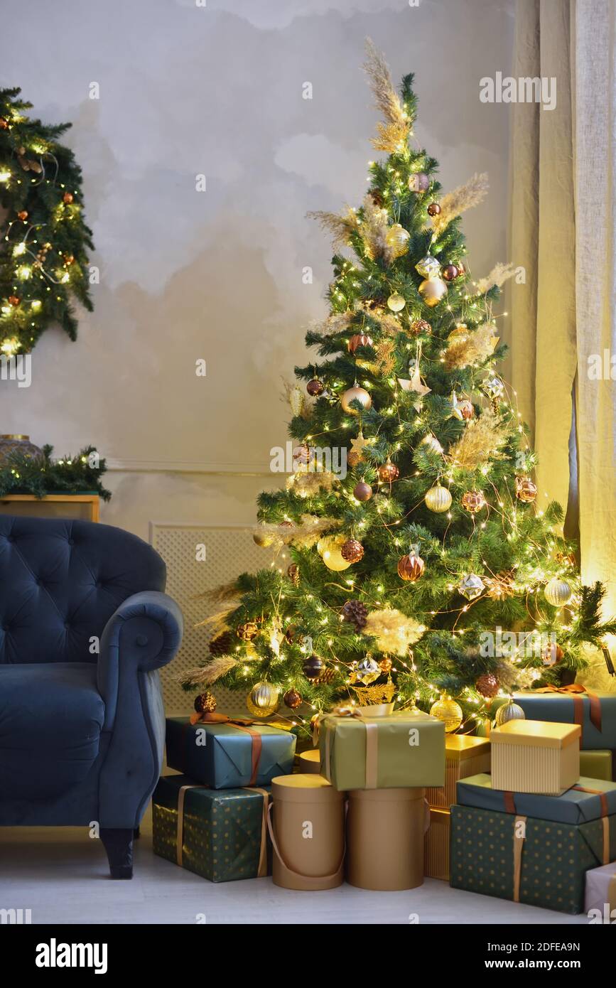 Weihnachtsbaum mit gelben Girlanden und Geschenken Stockfoto