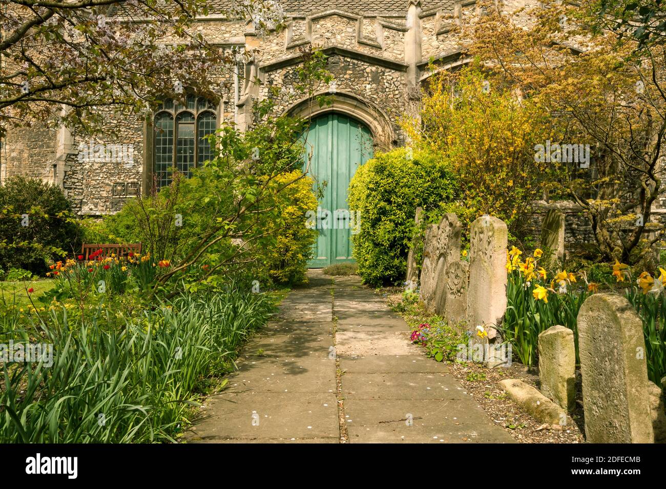 CAMBRIDGE, Großbritannien - 24. APRIL 2010: Pfad durch den Friedhof, der zur alten hölzernen Bogentür der St. Botolph's Parish Church führt Stockfoto