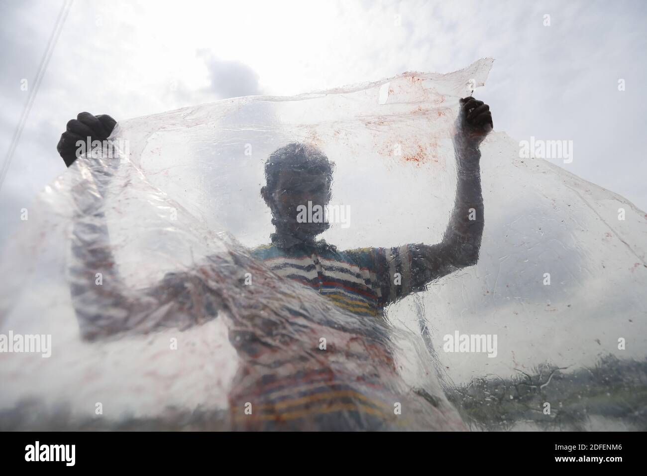 Ein Mann aus Bangladesch trocknet Plastikmüll, nachdem er sie im Wasser des Turag-Flusses in Tongi, in der Nähe von Dhaka, Bangladesch, gewaschen hat, 9. Juli 2020. Foto von Kanti das Suvra/ABACAPRESS.COM Stockfoto