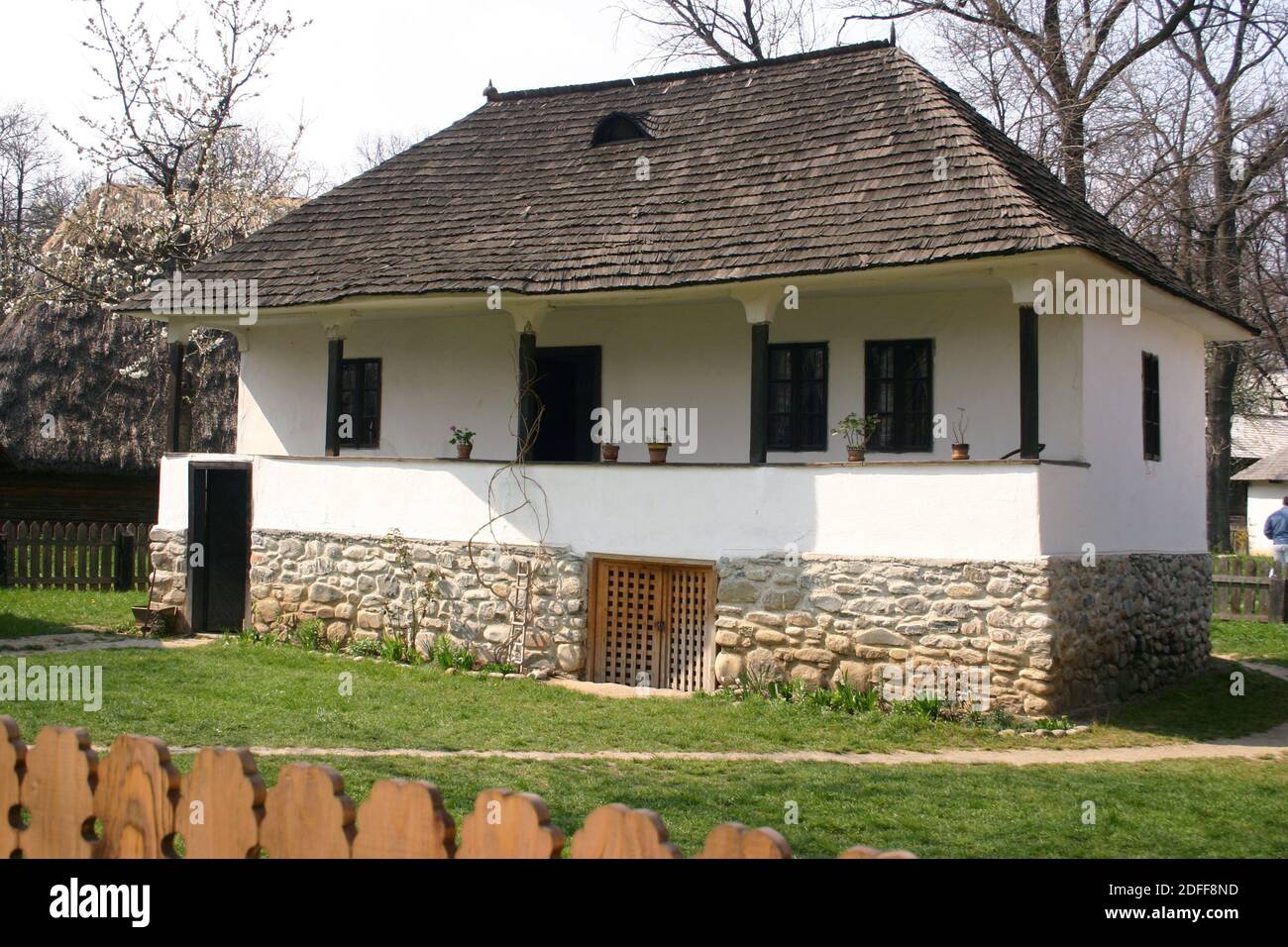 Das Dorfmuseum, Bukarest, Rumänien. Holzhaus aus dem 19. Jahrhundert aus der Grafschaft Arges, mit Holzschindeldach, Balkon, Steinfundament und Keller. Stockfoto