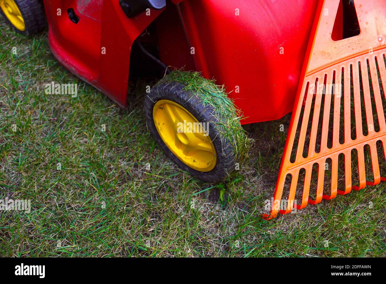 Herbst Zubehör für die Arbeit im Garten.Gartengeräte. Rasenmäher und Rechen. Stockfoto