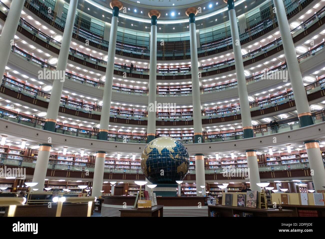 Schöne und ästhetische Innenansicht eines sehr überfüllten luxuriösen Große Bibliothek mit einem Globus mit Lerntischen und abgerundet Bücherregale Stockfoto