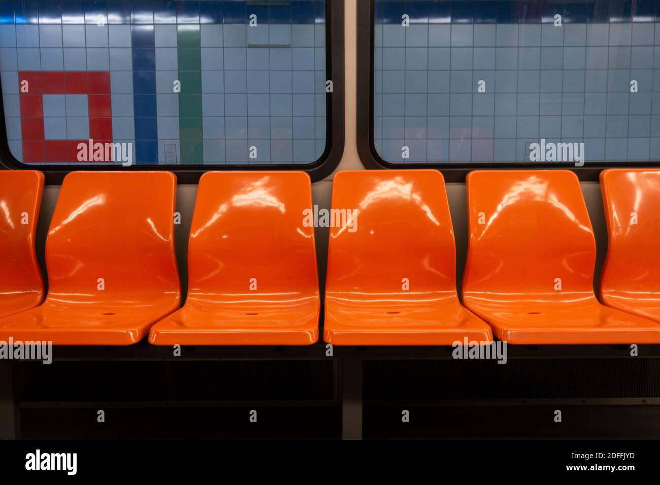 Leere orangefarbene Sitze innerhalb einer U-Bahn am Bahnhof Während der Quarantäne Stockfoto
