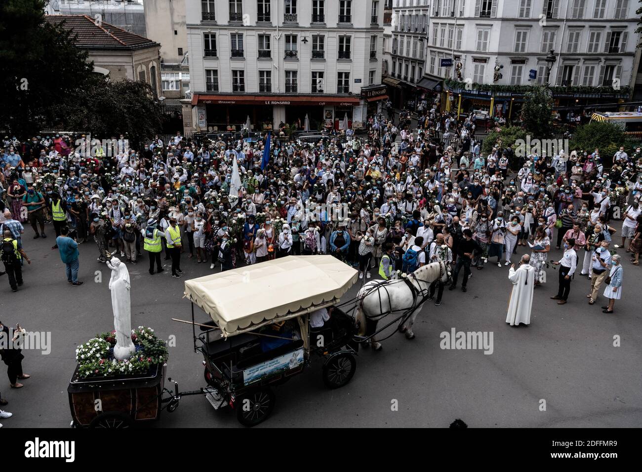 Die Prozession der Pilger auf der Straße M de Marie geht in der Straße von Paris, um die Basilika Sacré Coeur in Montmartre zu erreichen, mit weißen Rosen und nach einem Statut der Jungfrau Maria mit ihrem Kind am Tag der Himmelfahrt, eine katholische und orthodoxe Feier. Paris, Frankreich 15. August 2020. Foto von Daniel Derajinski/ABACAPRESS.COM Stockfoto