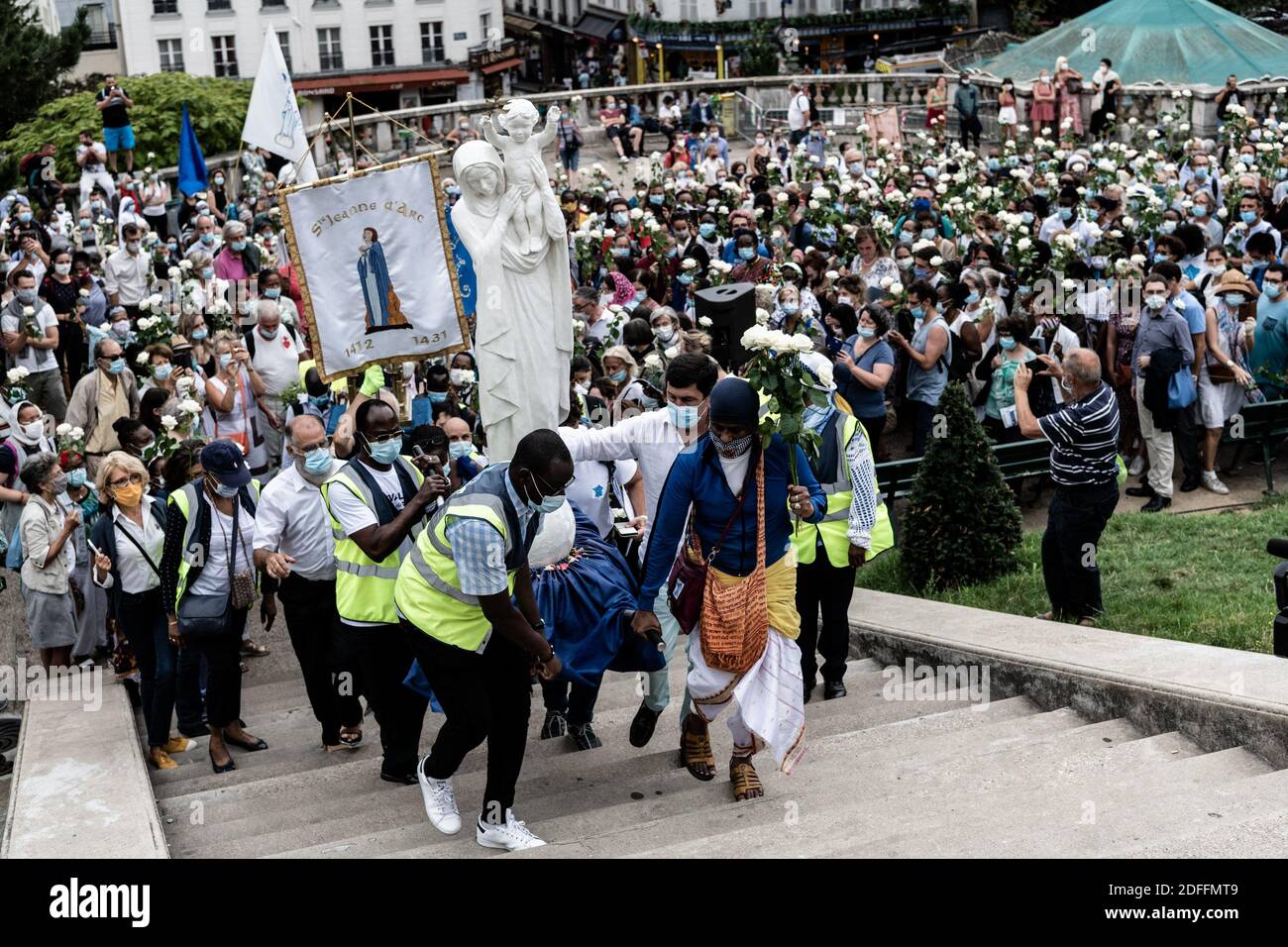 Die Prozession der Pilger auf der Straße M de Marie geht in der Straße von Paris, um die Basilika Sacré Coeur in Montmartre zu erreichen, mit weißen Rosen und nach einem Statut der Jungfrau Maria mit ihrem Kind am Tag der Himmelfahrt, eine katholische und orthodoxe Feier. Paris, Frankreich 15. August 2020. Foto von Daniel Derajinski/ABACAPRESS.COM Stockfoto