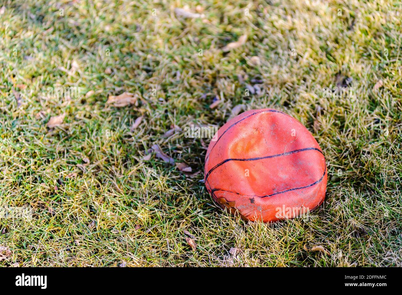 Entflat schmutzigen orange Basketball auf Gras. Stockfoto