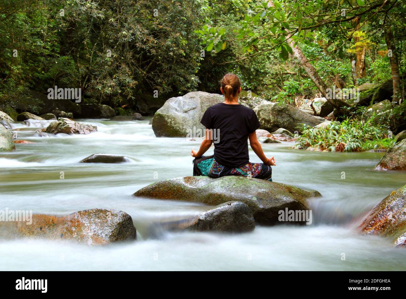 Eine Frau praktiziert Meditation und fühlt die Verbindung mit der Natur. Stockfoto