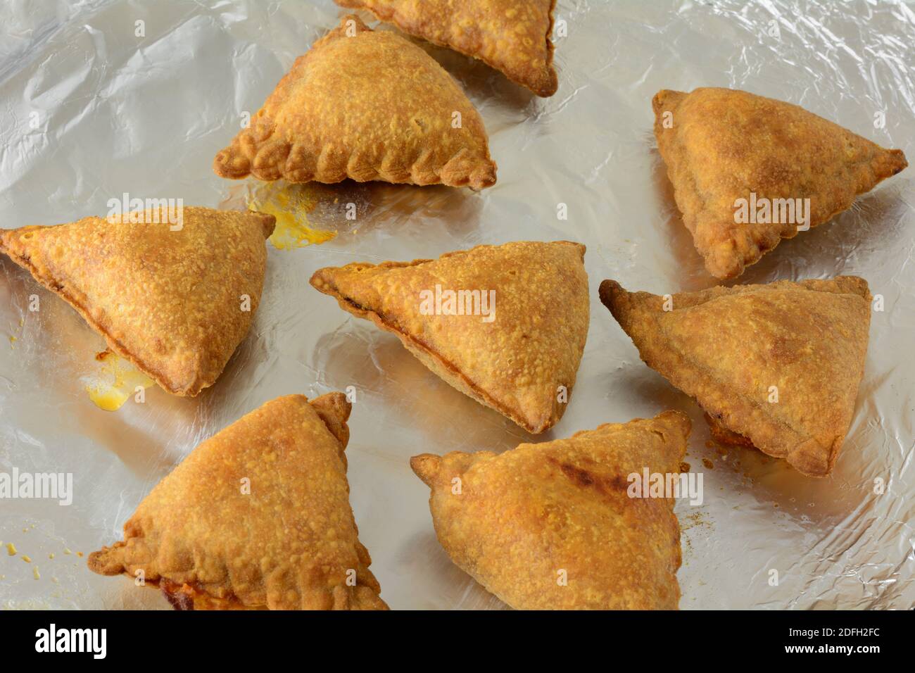 Heiß aus dem Ofen gebackene Samosa Snacks oder Vorspeisen Auf Aluminiumfolie auf Backblech Stockfoto