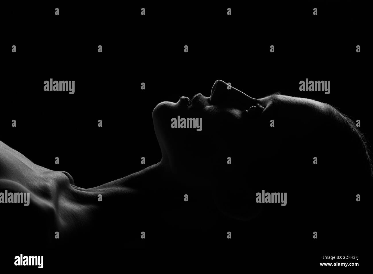 Traurige Frau Profil Silhouette auf schwarzem Hintergrund suchen nach oben, monochrom Stockfoto