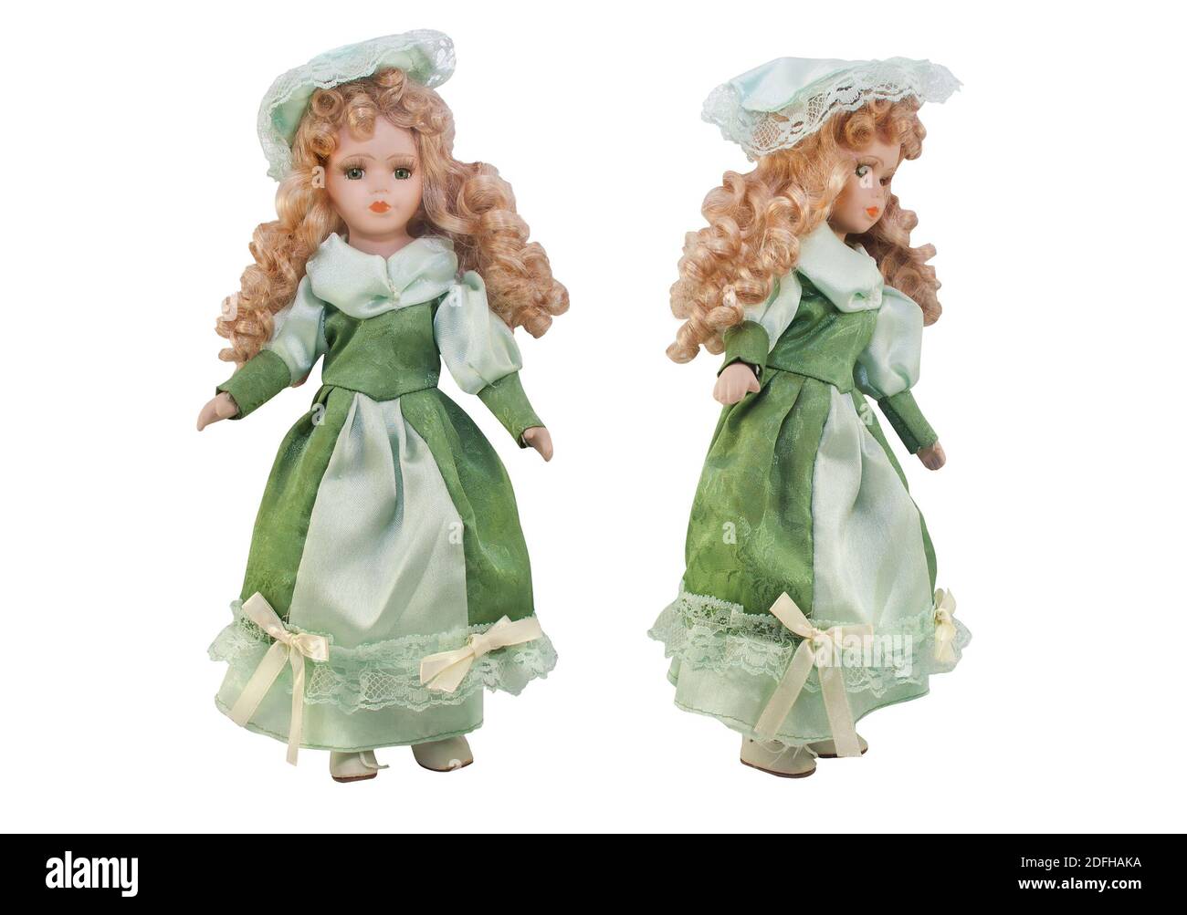 Isoliertes Foto von altmodischen Puppe in grünem Kleid mit Hut und lockiges Haar auf weißem Hintergrund. Stockfoto