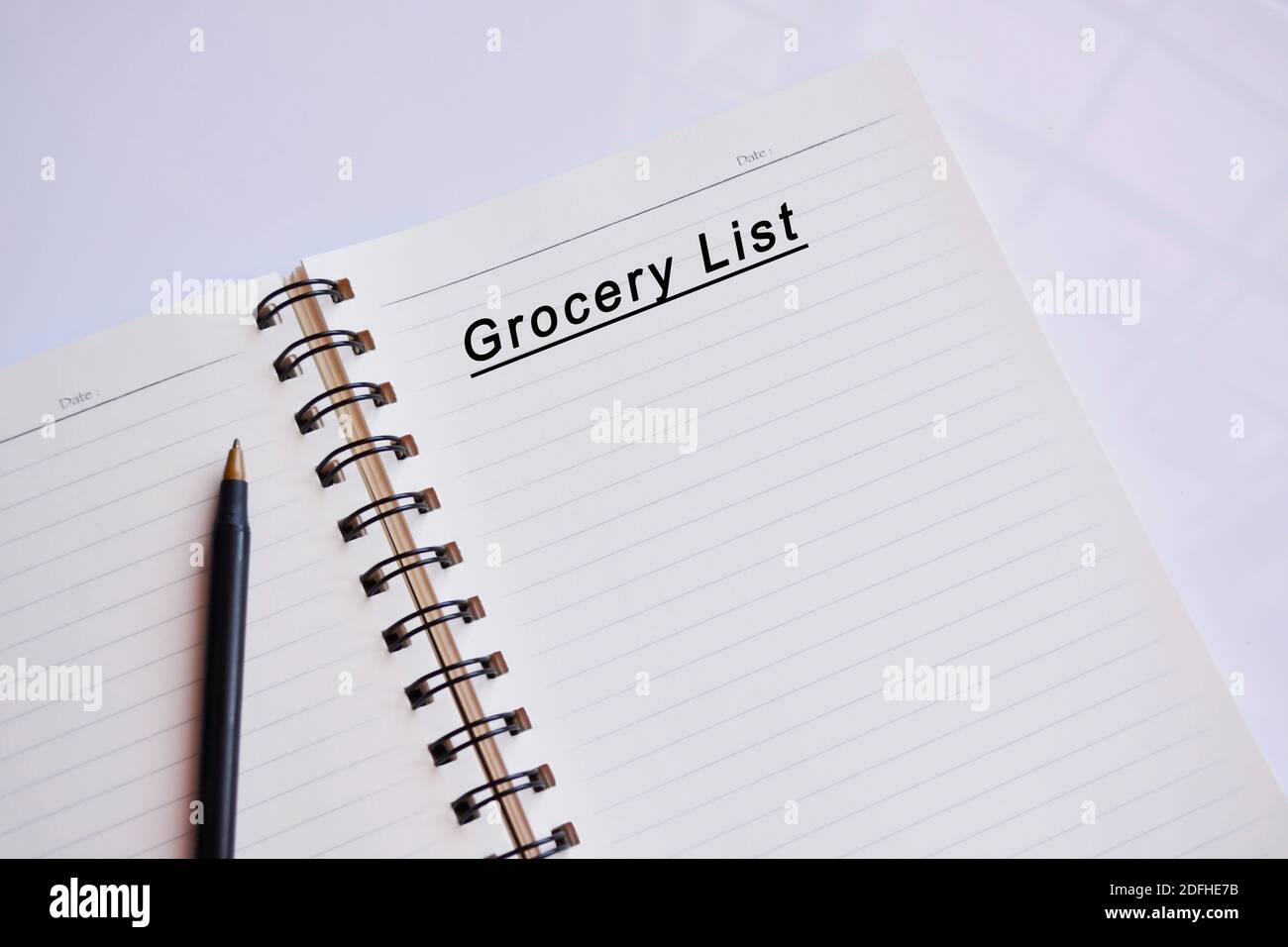 Lebensmittelgeschäft Liste Text auf einem Notizblock mit Spiegelung von Fenster Glas. Haushaltsbudget-Konzept Stockfoto