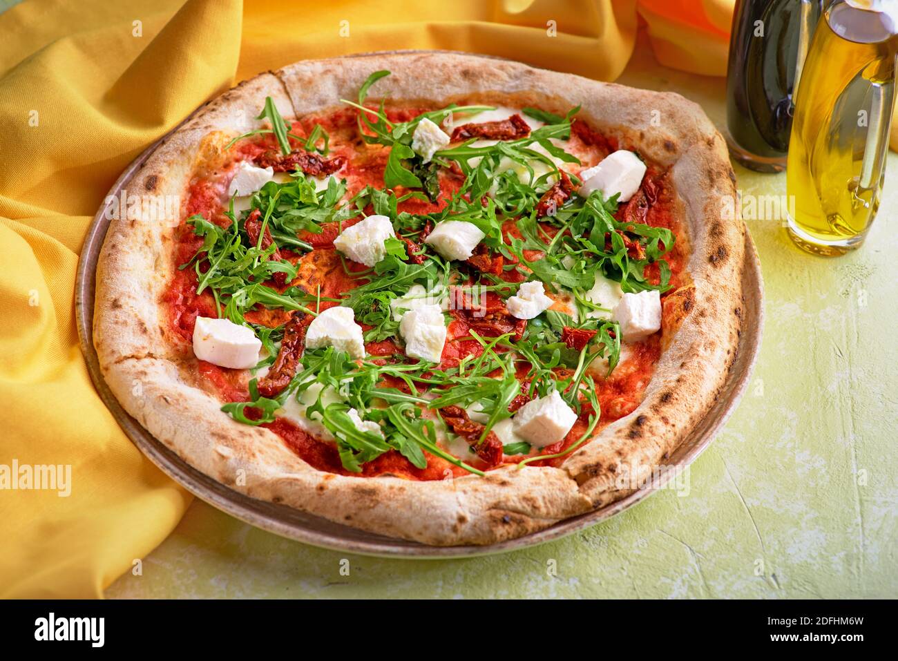 Gesunde Quinoa Pizza mit sonnengetrockneten Tomaten und Ziegenkäse. Konzept der gesunden Ernährung für das Menü. Stockfoto