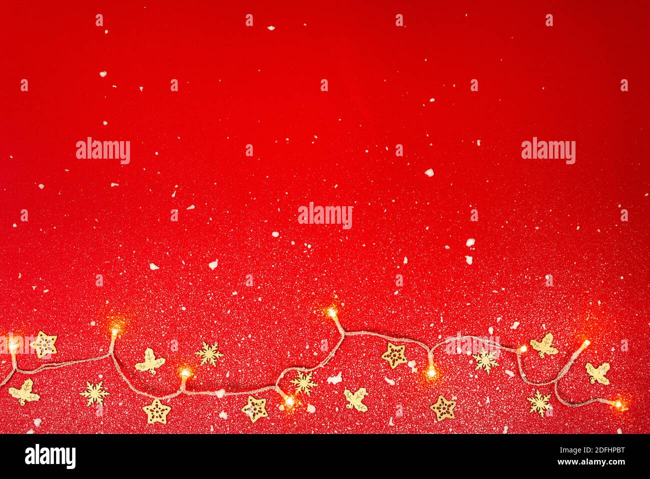 Einige kleine dekorative Ikonen und Feiertagslichter auf einem roten Hintergrund Stockfoto
