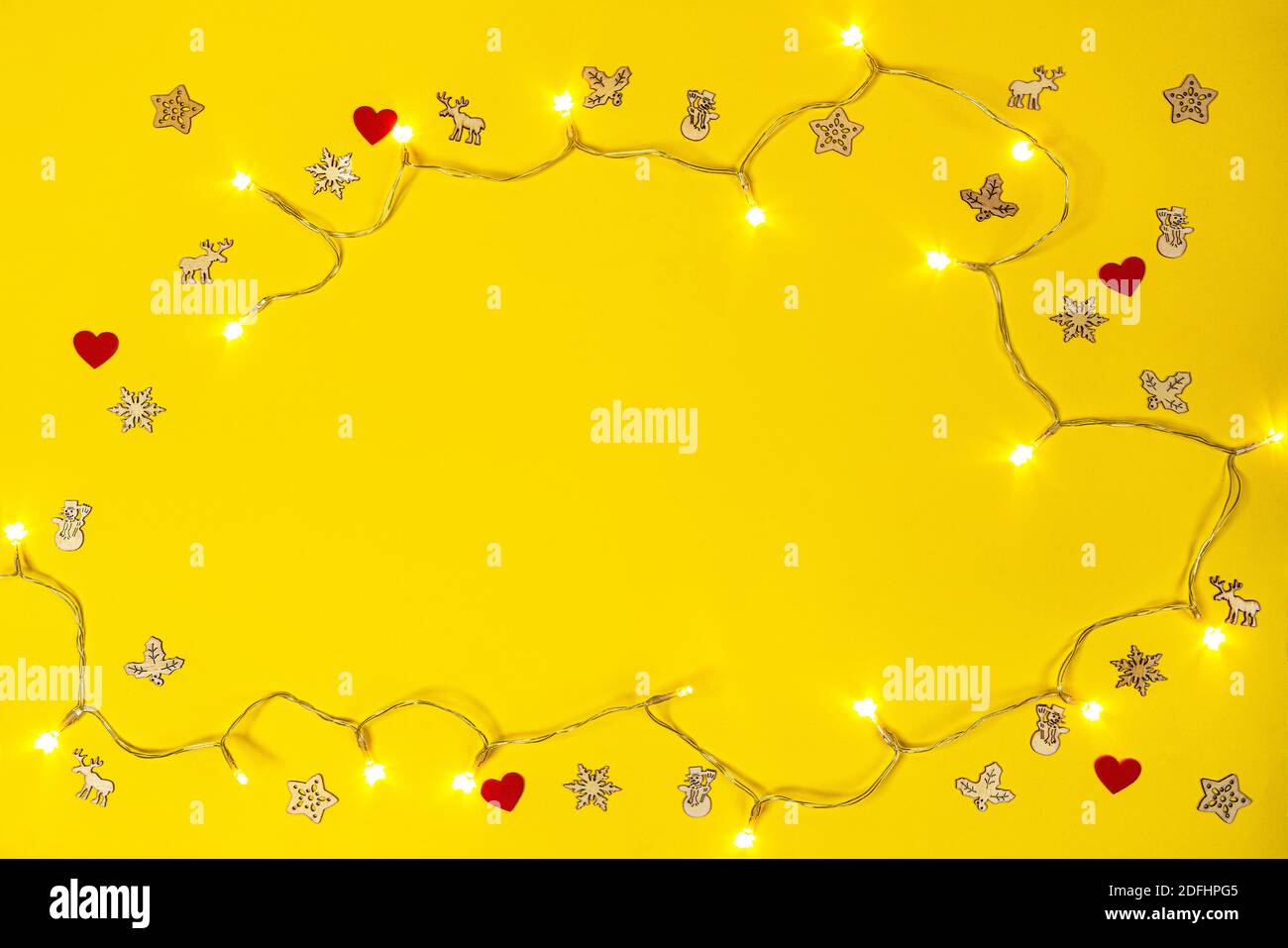 Einige kleine dekorative Ikonen und Feiertagslichter auf einem gelben Hintergrund Stockfoto