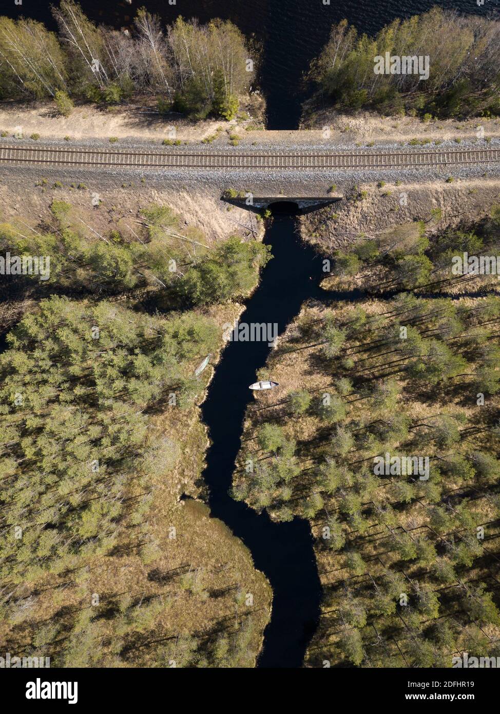 Eisenbahn, die einen Fluss überquert, der zum See führt Stockfoto