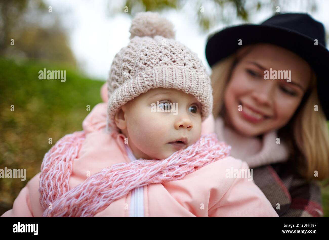 Schöne Baby-Mädchen mit Mutter im Freien. Familien im Freien. Liebenswert kleines Mädchen in warmen Kleidern im Herbst Park an sonnigen Tag. Stockfoto