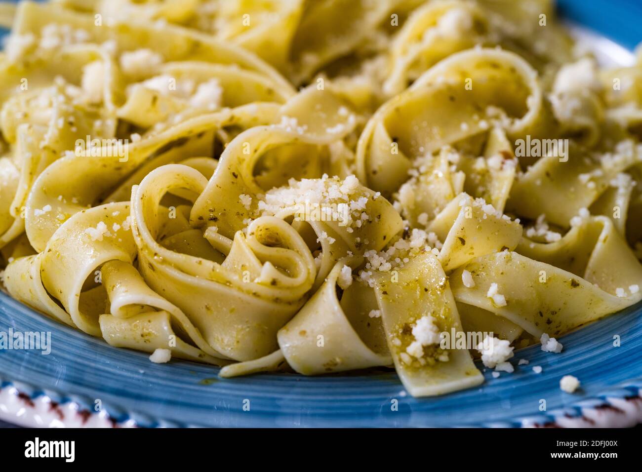Pappardelle Pasta mit geriebenem Parmesan-Käse par in Teller bereit zu servieren und zu essen / Makro Nahaufnahme Ansicht. Traditionelles Essen. Stockfoto