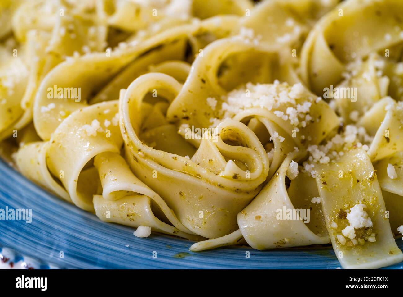 Pappardelle Pasta mit geriebenem Parmesan-Käse par in Teller bereit zu servieren und zu essen / Makro Nahaufnahme Ansicht. Traditionelles Essen. Stockfoto