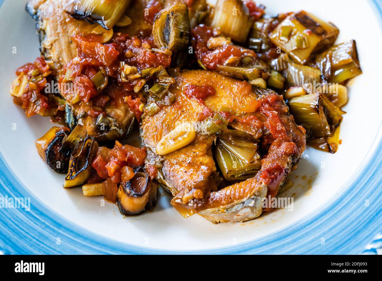 Bonito Fischstücke mit Tomatensauce und Lauch in Teller gebacken im Ofen /  Fischauflauf. Bereit zu servieren und zu essen Stockfotografie - Alamy