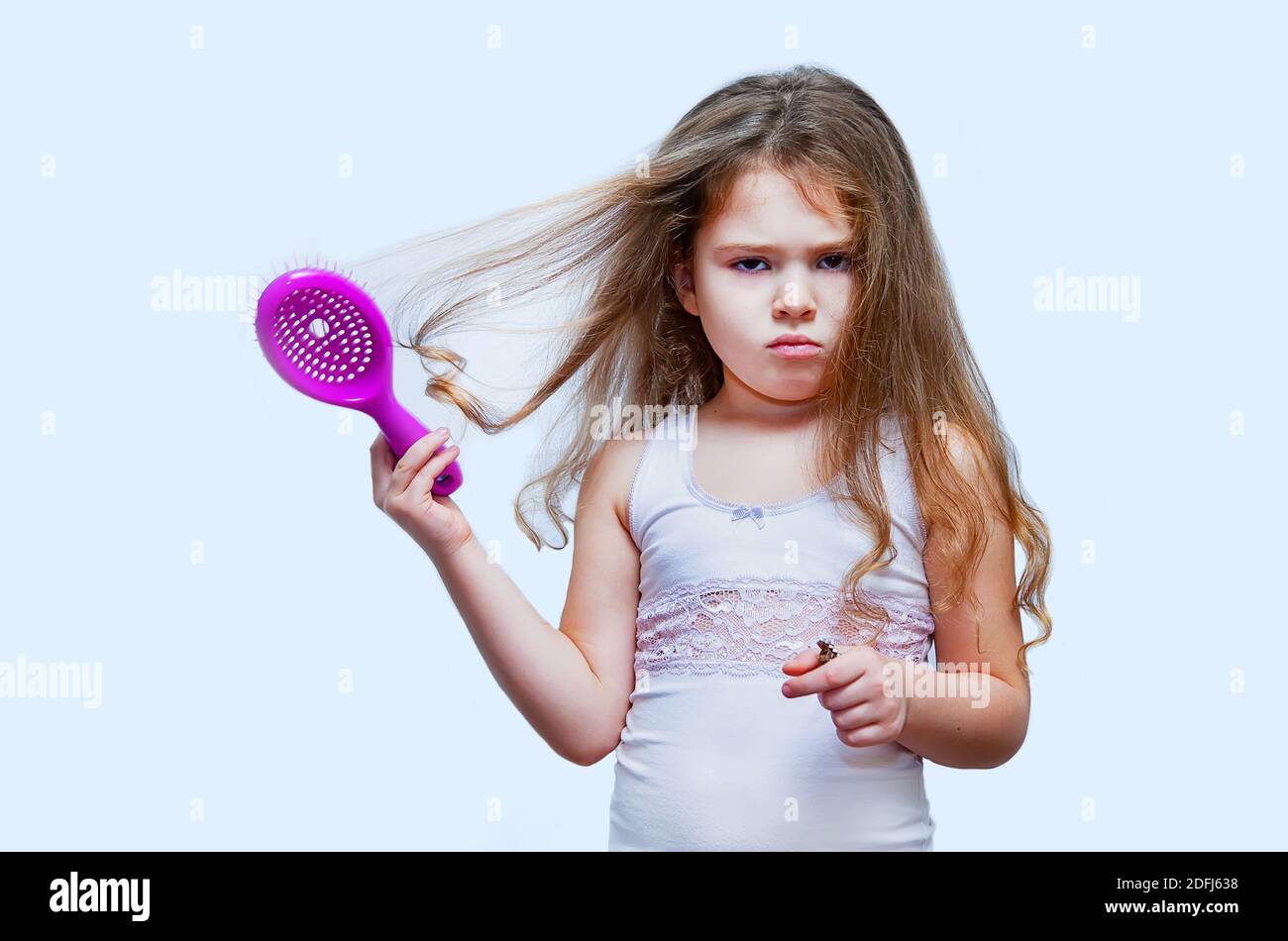 Haarpflegekonzept mit Porträt eines Mädchens, das ihr widerspenstiges, verworrenes langes Haar putzt Stockfoto