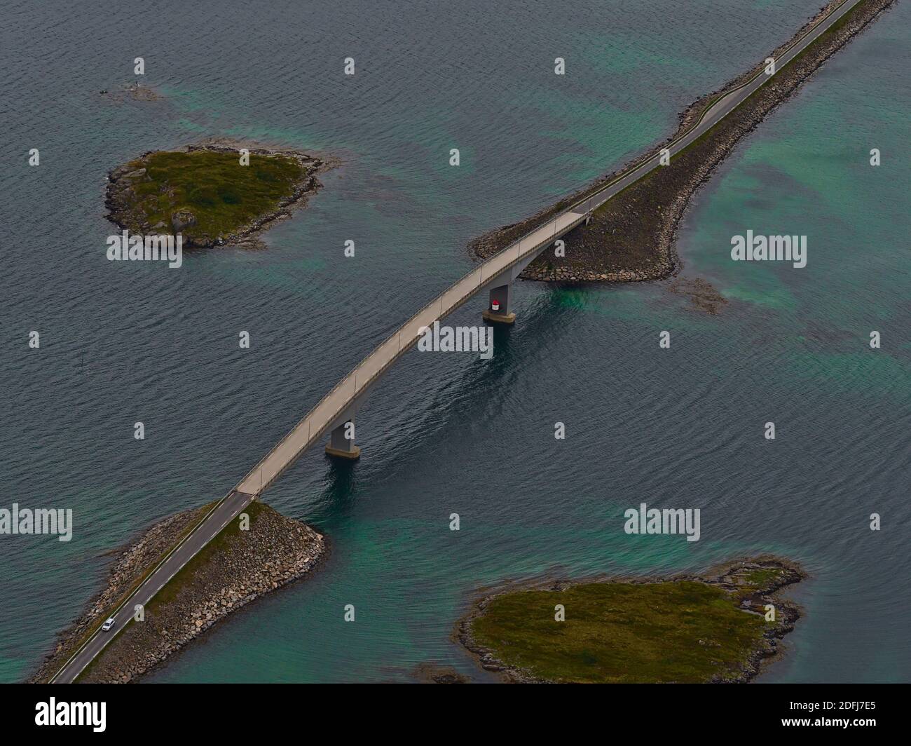 Luftaufnahme der Fredvang Straßenbrücke, die zwei Inseln Flakstadøya und Moskenesøya auf den Lofoten, Norwegen, mit felsigen Inseln und flachem Wasser verbindet. Stockfoto