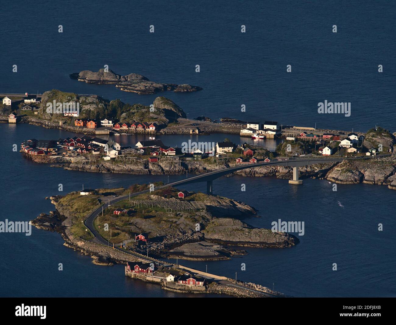 Atemberaubende Luftaufnahme des kleinen Fischerdorfes Hamnøy auf Inseln an der Küste der Insel Moskenesøya, Lofoten, Norwegen mit Brücke und Häusern. Stockfoto