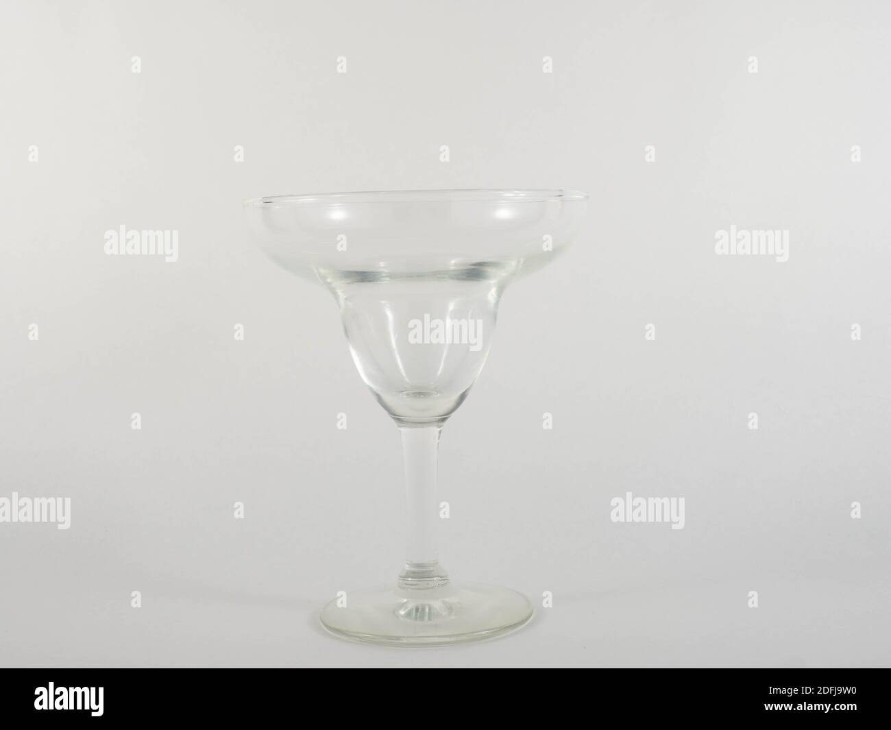 Ein transparentes Cocktailglas. Konzept über die Welt der Party und des Geldes. Stockfoto