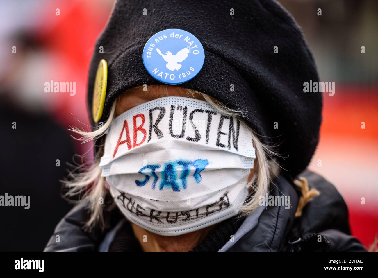 Deutschland, Berlin, 05. Dezember 2020: Eine in ihr tief ins Gesicht gezogene Demonstratorin mit der Aufschrift "Aufrüstung statt Aufrüstung" kann als Friedensaktivisten vor dem Bundeskanzleramt gegen steigende Rüstungsausgaben im Rahmen der anstehenden Haushaltsdiskussionen im Deutschen Bundestag nächste Woche protestieren. Die Organisatoren der Friedensinitiative "Abrüstung statt Aufrüstung" rufen beim bundesweiten Tag für "Abrüstung und eine neue Politik der Entspannung" zu einem Einschnitt der deutschen Rüstungsexporte und einer Socia auf Stockfoto