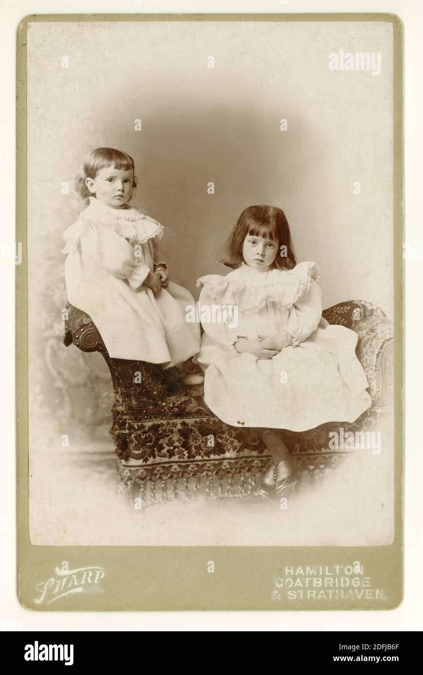 63-VBW1421 viktorianische Kabinettkarte von zwei ernsthaft aussehenden, hübschen Schwestern namens Peggie und Ruby Purdie, viktorianische Mädchen, aus der Gegend um Hamilton, nahe Glasgow, South Lanarkshire, Schottland, Großbritannien um 1897, 1898, 1899. Stockfoto