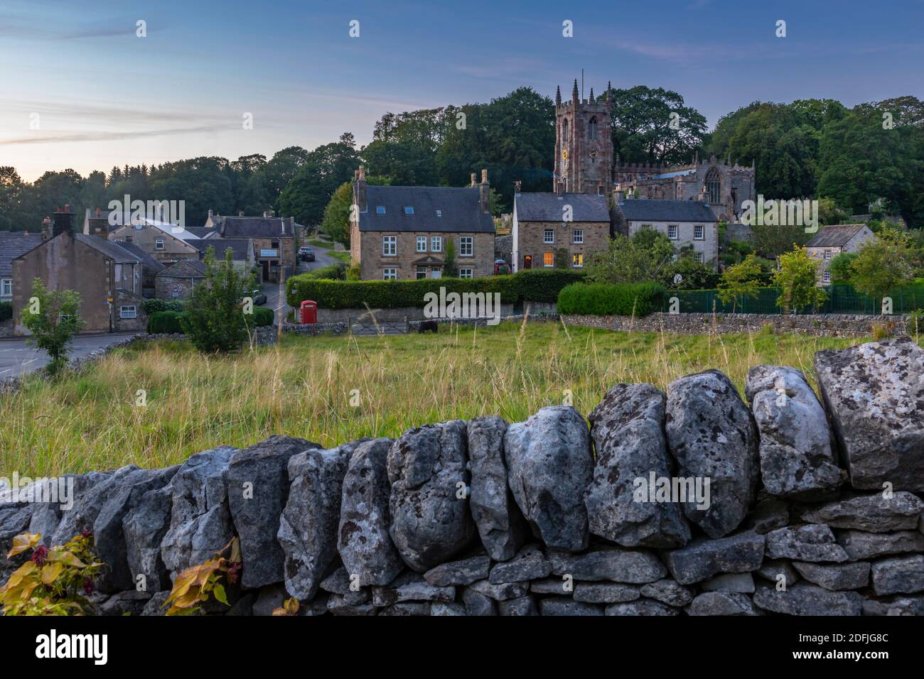 Blick auf Trockenmauern und St. Giles' Church in der Abenddämmerung, Hartington, Peak District National Park, Derbyshire, England, Großbritannien, Europa Stockfoto
