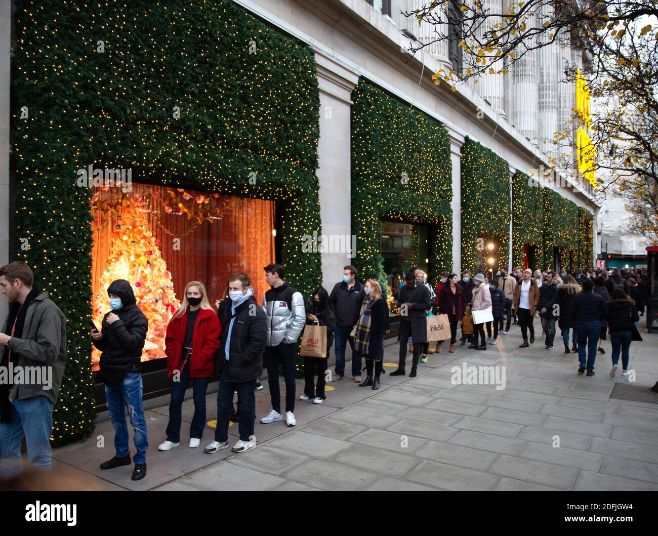 London, Großbritannien. Dezember 2020. Einkäufer stehen Schlange, um in Selfridge's zu kommen. Geschäftige Einkäufer in Londons Oxford Street, während die Menschen nach dem Ende der Sperre ausgehen. Kredit: Mark Thomas/Alamy Live Nachrichten Stockfoto