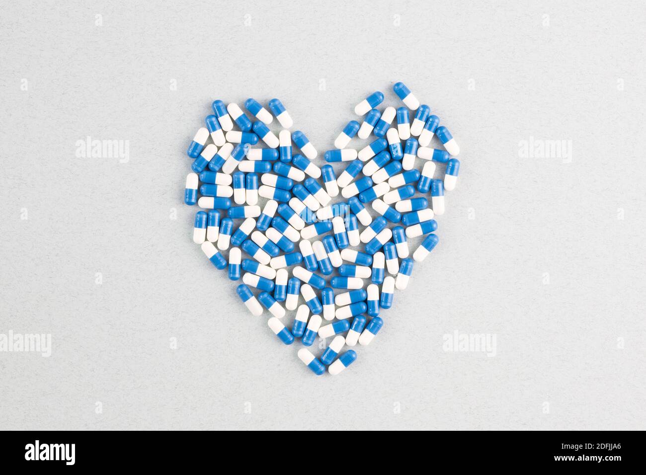 Blau-und weiße Pillen bilden große Herzform über weißem Hintergrund Mit Copyspace umgibt es, die für junge verwendet werden kann Nachricht Stockfoto