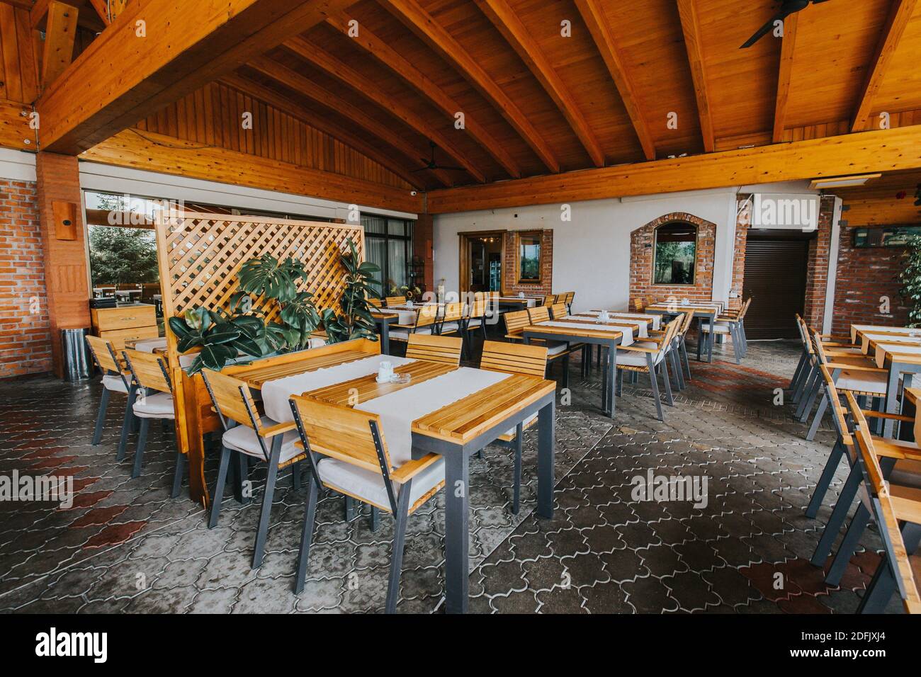 Ein Restaurant im Freien mit Holzstühlen und -Tischen Stockfoto