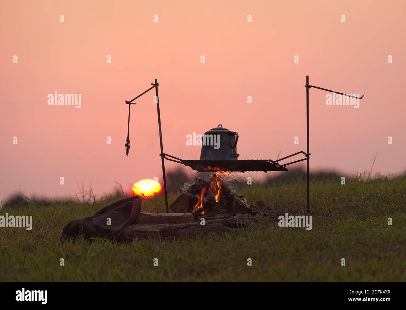 Teekocher auf einem Feuer bei Sonnenaufgang. Stockfoto