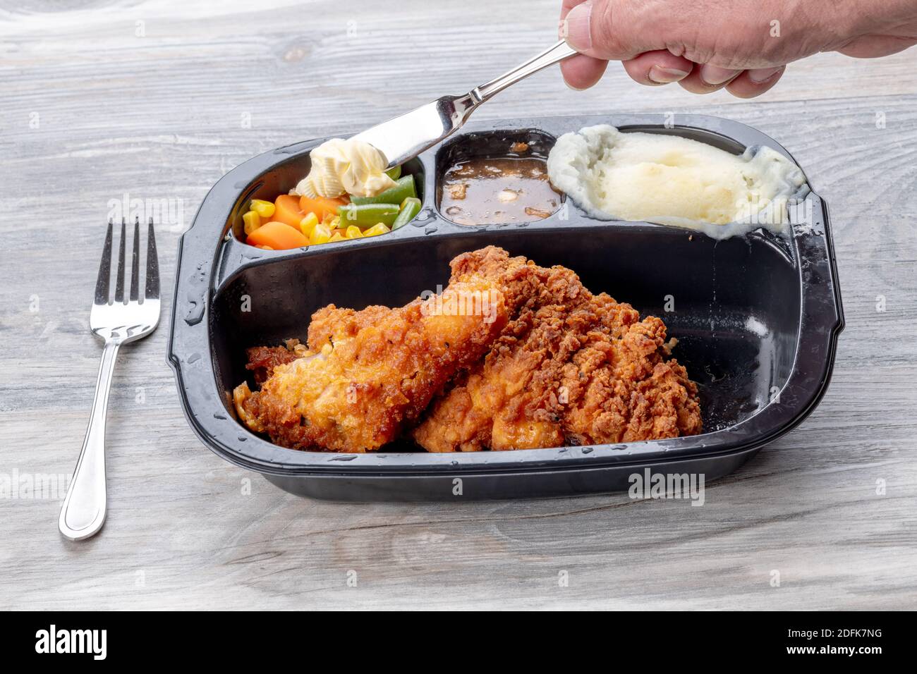 Bei einem Abendessen mit gebratenem Huhn Kartoffelpüree aufschlagen Stockfoto