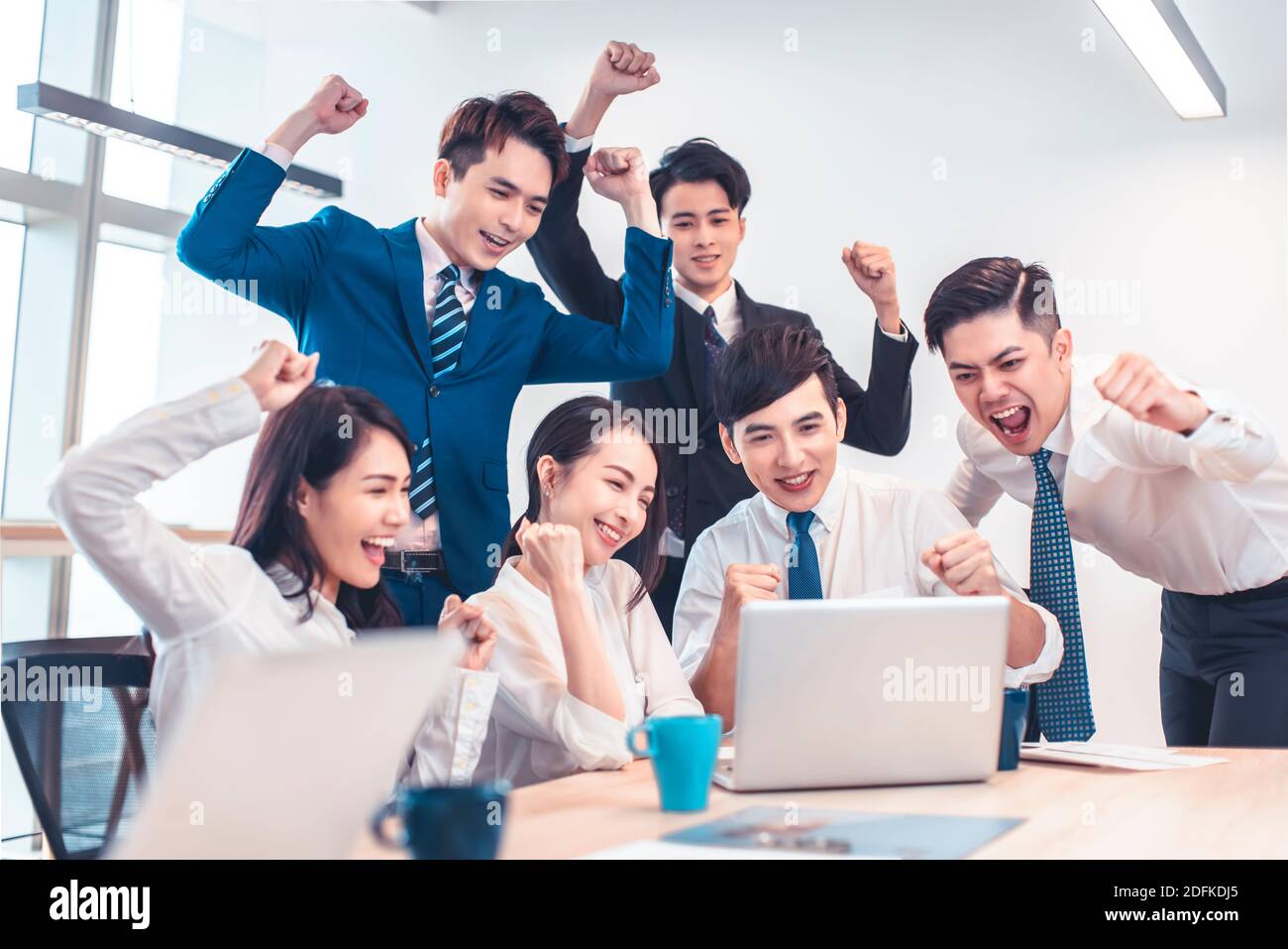 Das Business-Team des Unternehmens ist begeistert und sieht sich den Laptop in der Besprechung an Stockfoto