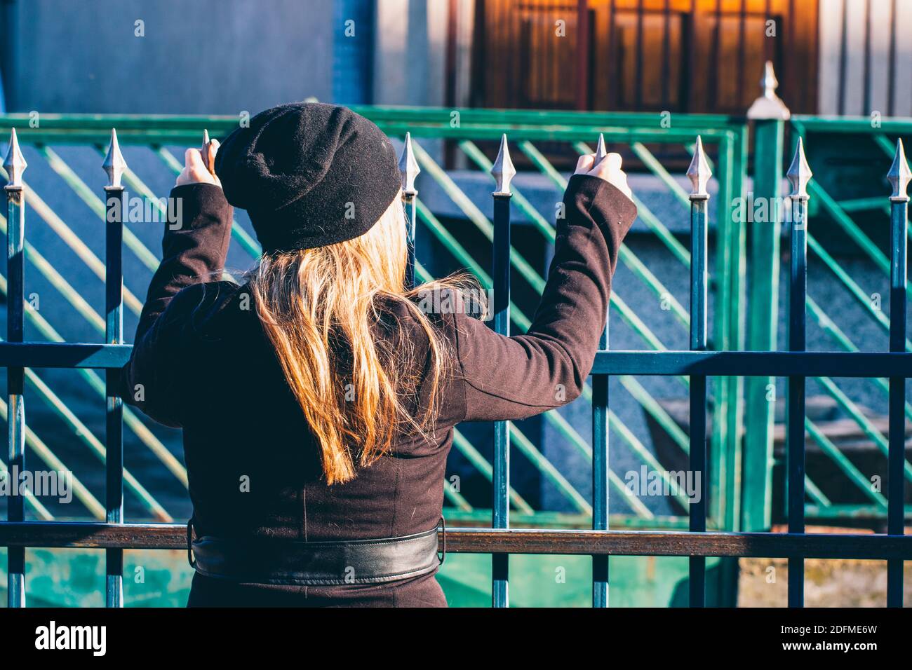 Eine Frau hinter dem Zaun Stockfoto