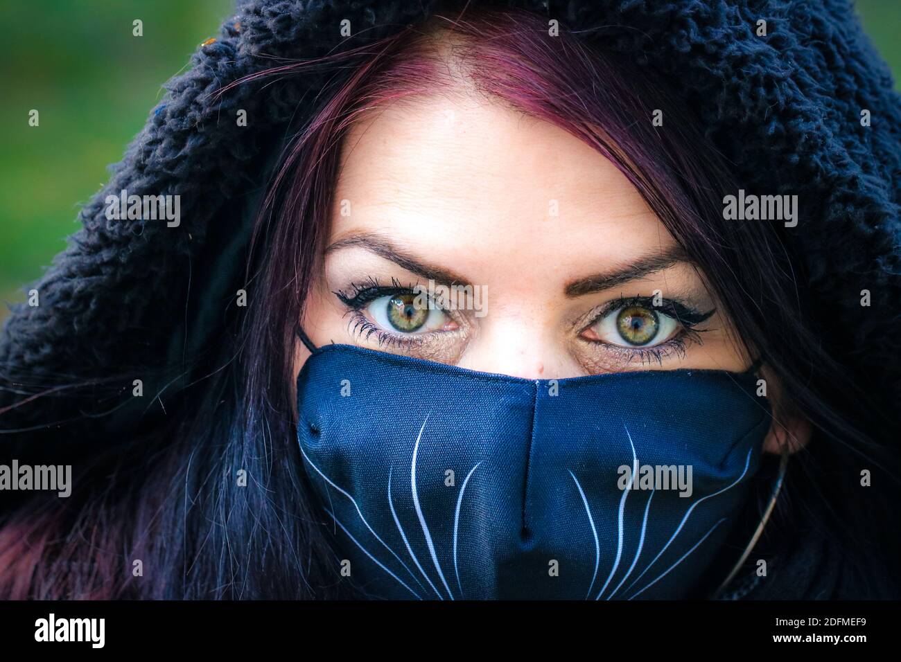 Mädchen mit grünen Augen trägt eine Maske Stockfoto