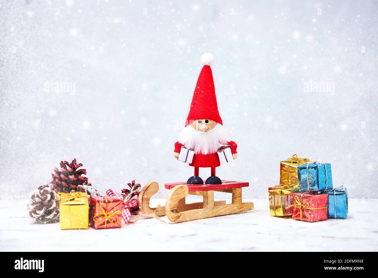 Weihnachtskarte. Santa gnome Hintergrund mit Geschenken und Schnee. Weihnachtssymbol. Stockfoto