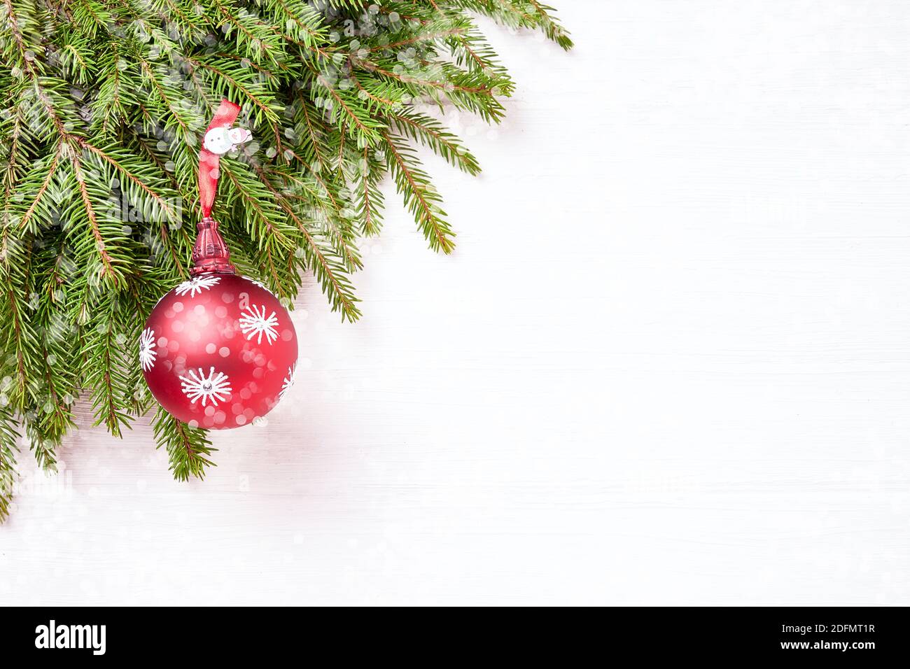 Weihnachtliche Grenze - Äste mit Bällen, Bokeh-Textur, weißer Hintergrund. Speicherplatz kopieren Stockfoto