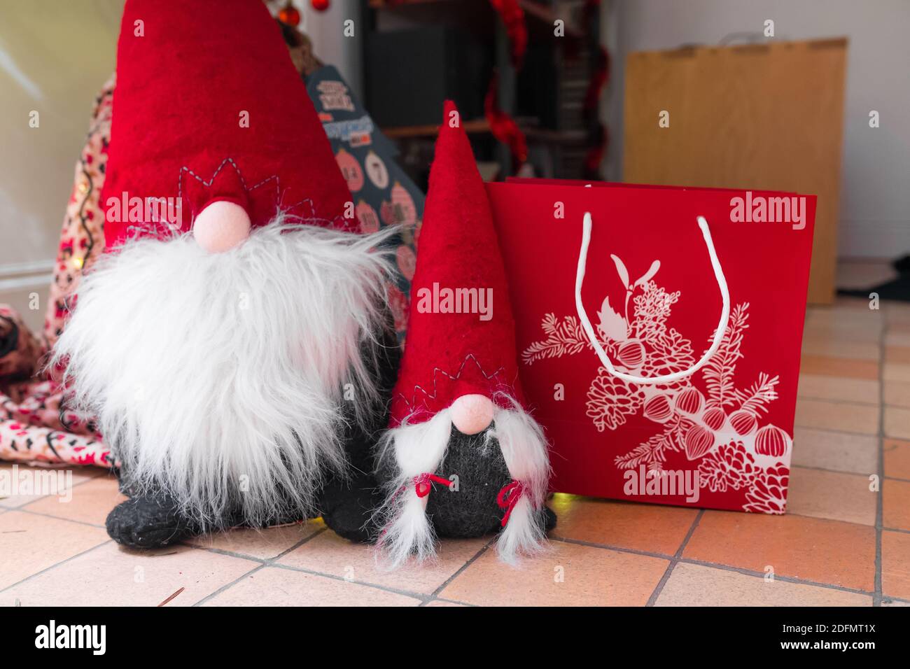 Weihnachten Zwerge mit einem schönen roten Einkaufstasche. Der eine hat einen großen Bart und der andere ist ein weiblicher Zwerg mit langen Haaren. Winterurlaub. Stockfoto