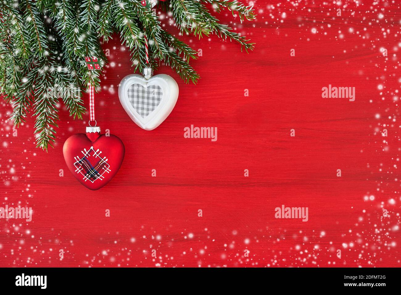 Weihnachtskarte. Tannenzweig mit Dekoration. Rote Weihnachten Hintergrund. Platz kopieren, Schneetextur. Stockfoto