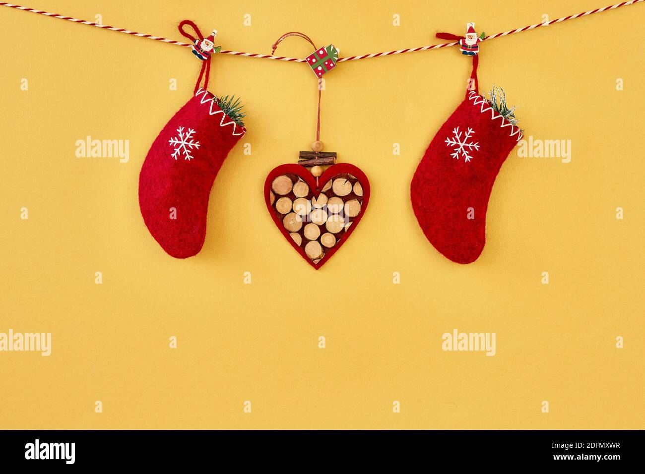 Weihnachten Hintergrund. Rote weihnachtssocken und Herz hängen am Seil auf goldenem Hintergrund. Speicherplatz kopieren. Stockfoto