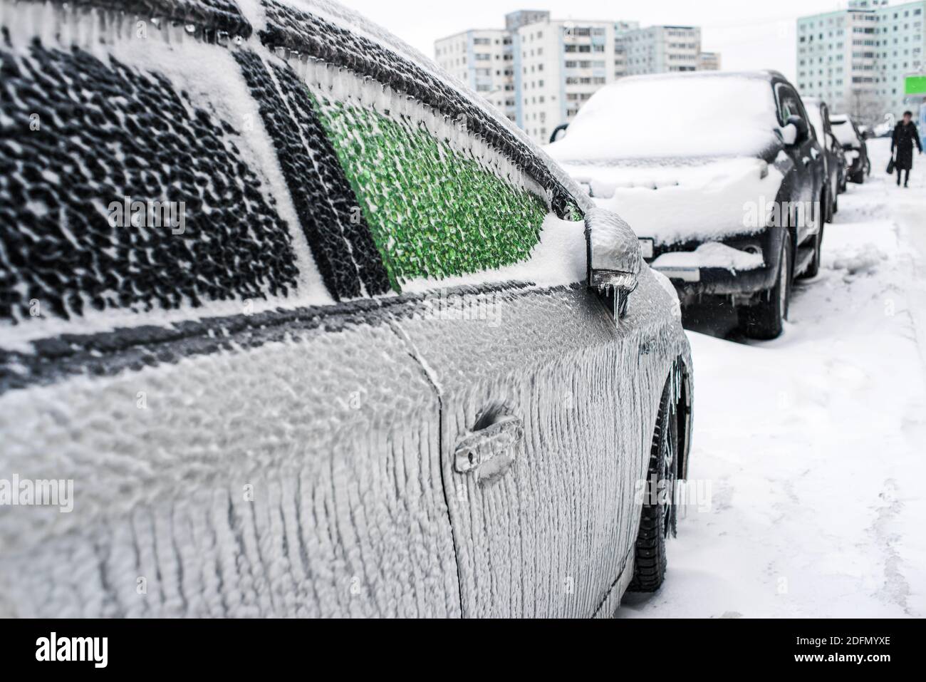 Auto mit Eis und Eiszapfen bedeckt nach Glatteisregen. Eissturmzyklon. Schneebedecktes Wetter. Stadt im Winter. Frostige Szenen im Winter. Stockfoto
