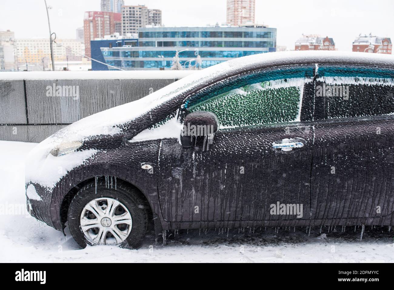 Auto mit Eis und Eiszapfen bedeckt nach eisigen Regen aus nächster Nähe. Eissturmzyklon. Stadt im Winter. Schneebedecktes Wetter. Frostige Szenen im Winter. Stockfoto