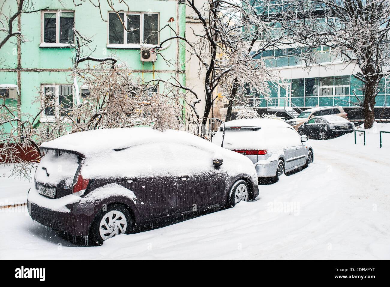 Verschneite Straße. Auto bedeckt mit Eis, Schnee und Eiszapfen. Eissturmzyklon. Winter frostiges Wetter. Stockfoto